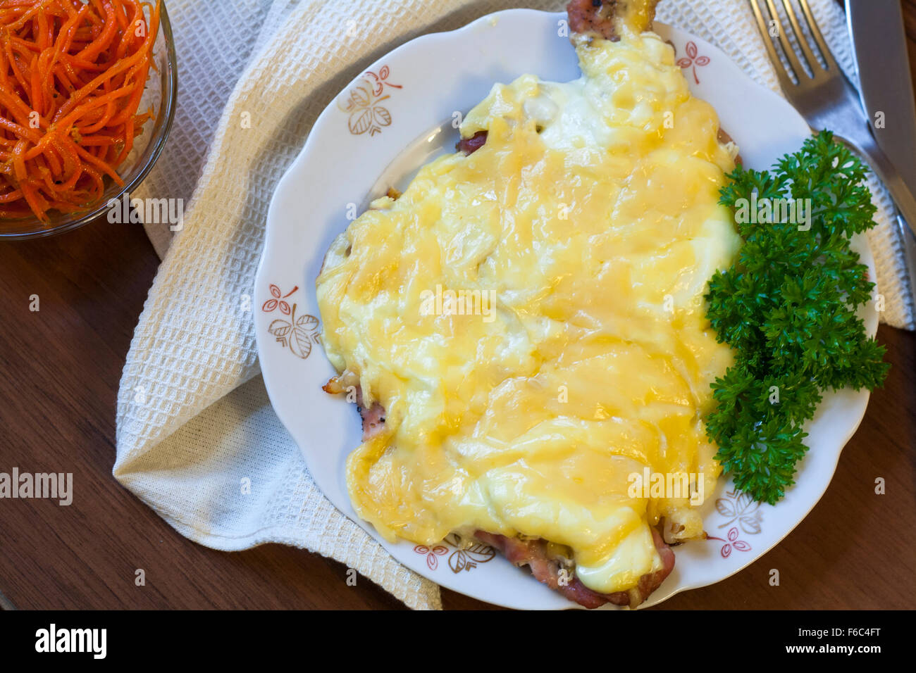 Baked pork chops with onion, mayonnaise cheese with fresh parsley on
