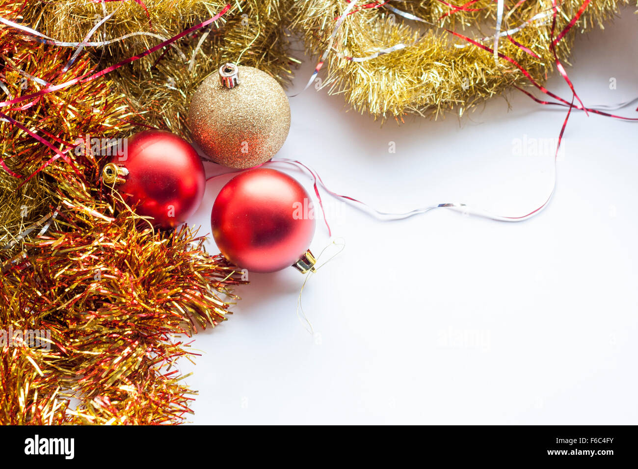 Red and gold decorative Christmas ball and garland on white background