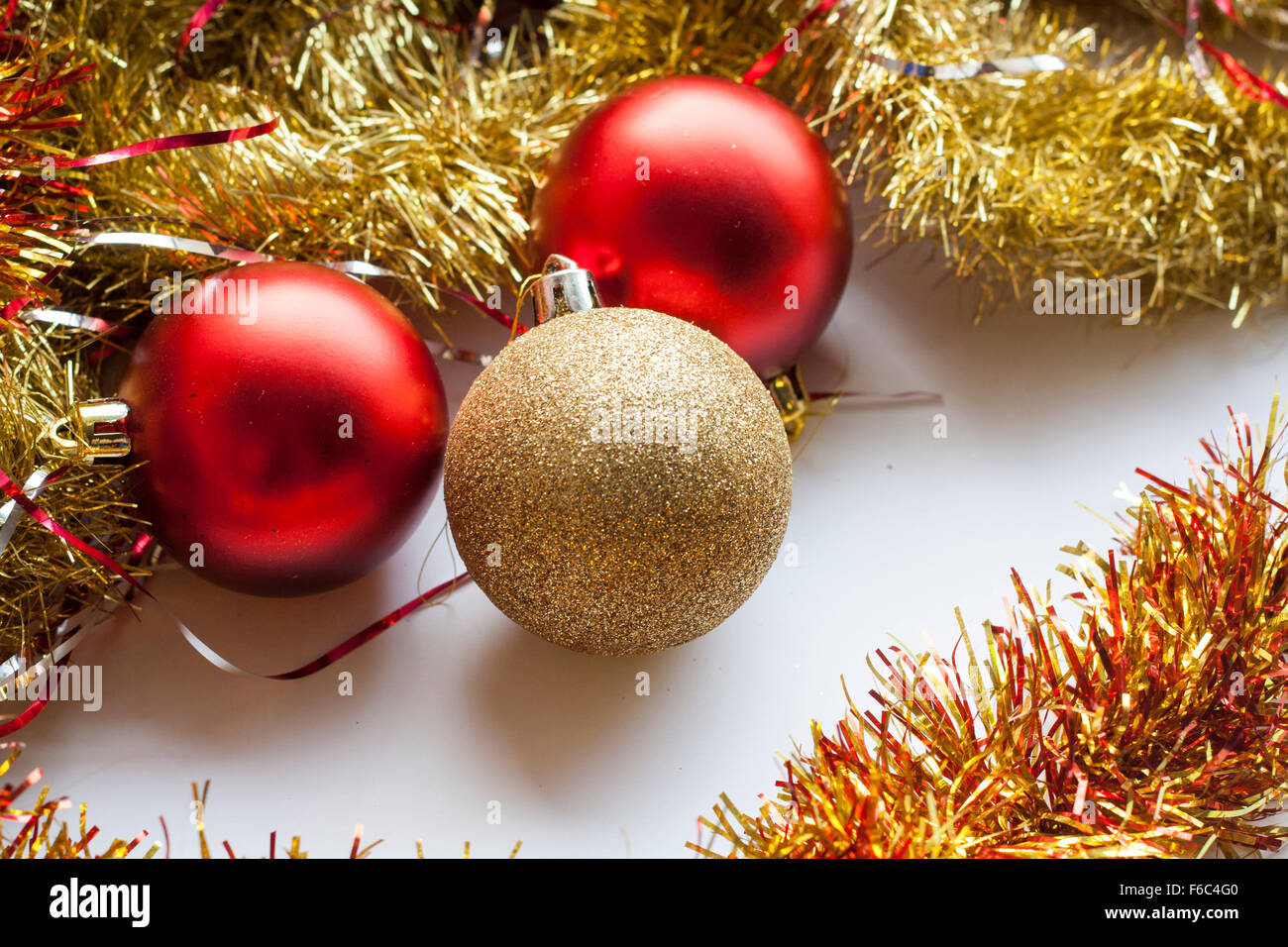 Red and gold decorative Christmas ball and garland on white background