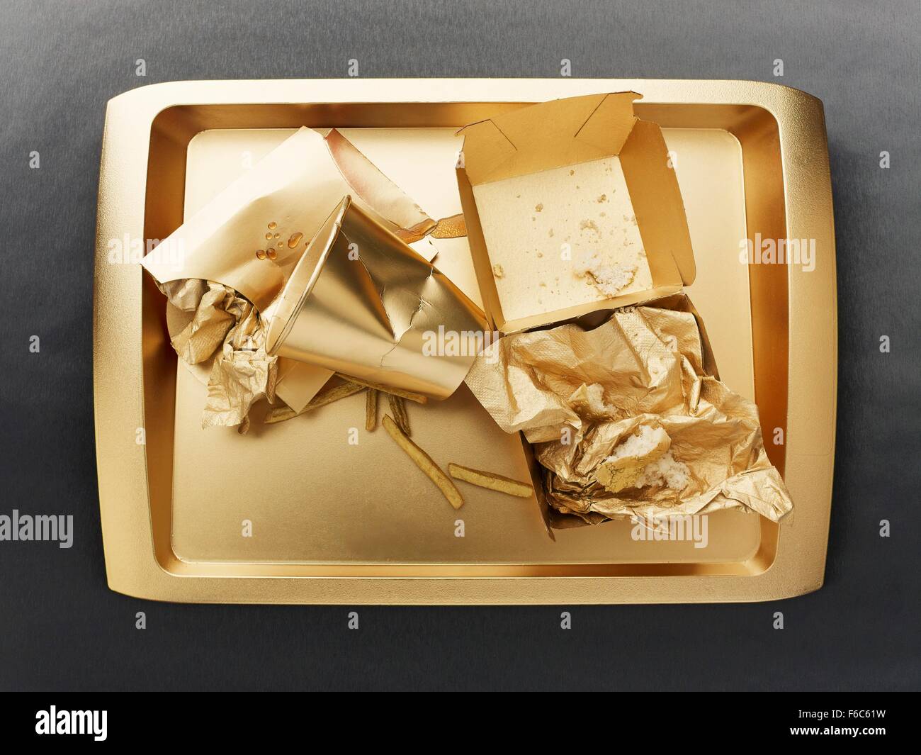 The remains of a fast food meal on a gold-coloured tray Stock Photo