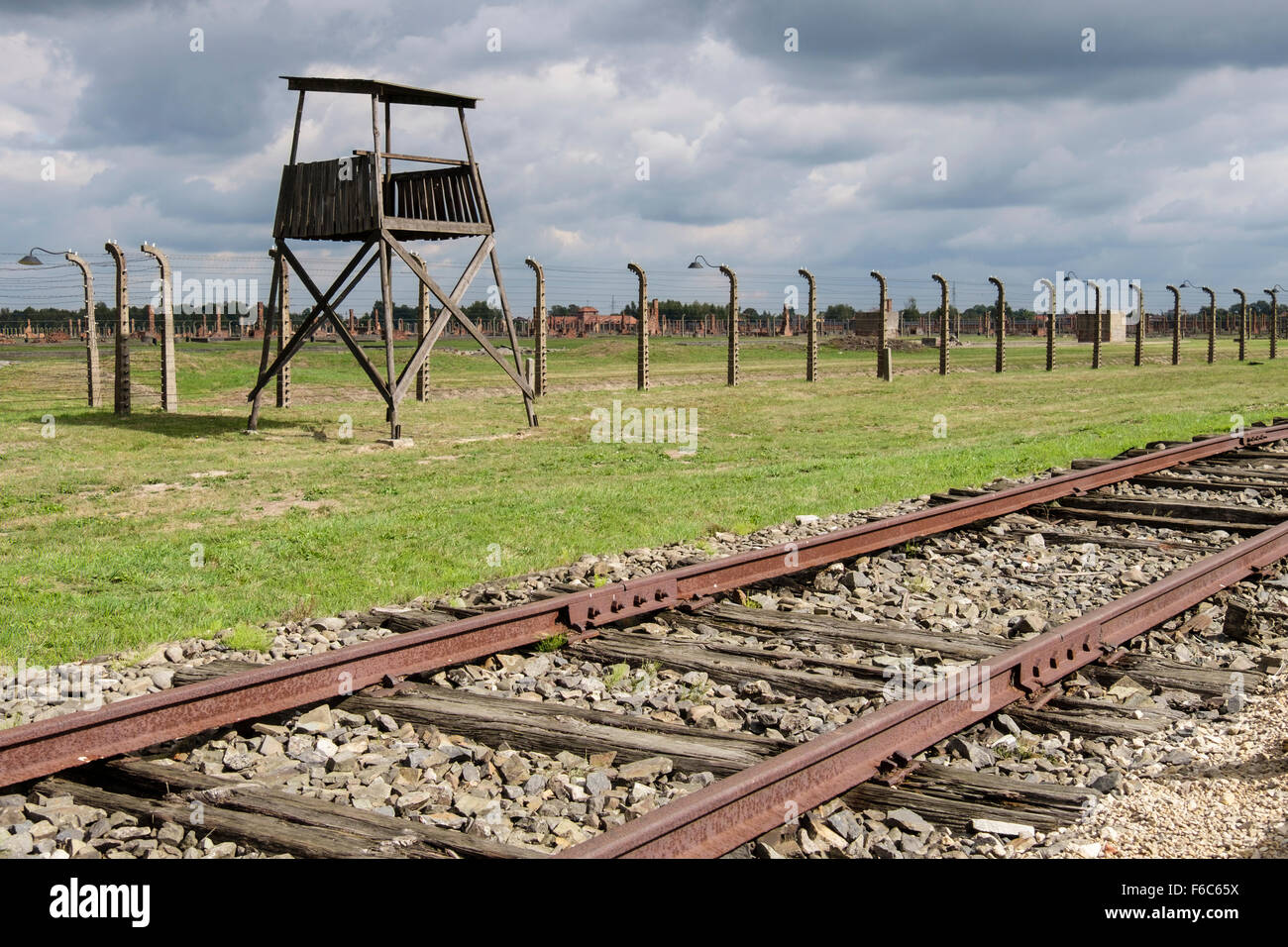 Railway line and guard tower by fence at Auschwitz II-Birkenau German Nazi Concentration and Extermination Camp. Oswiecim Poland Stock Photo