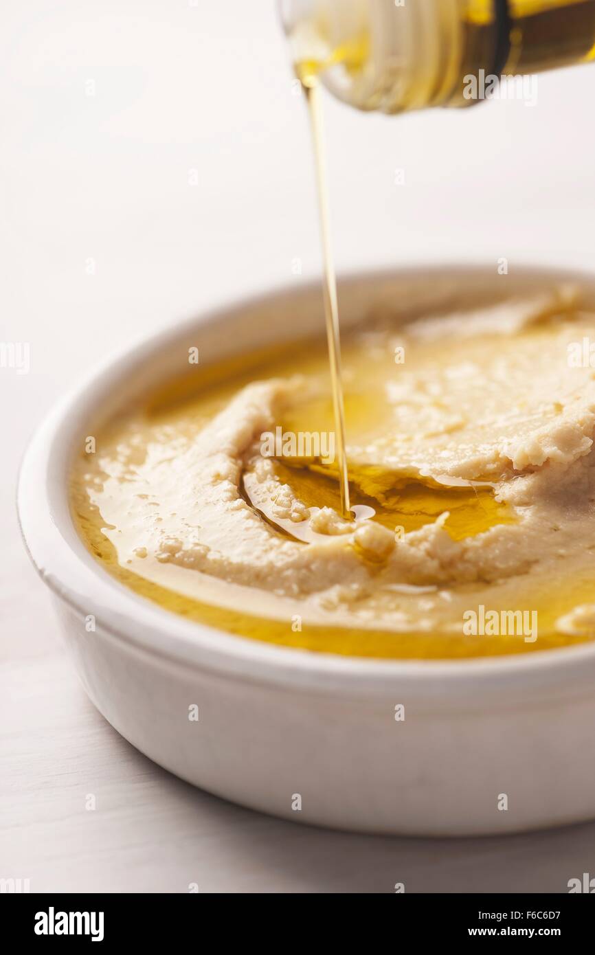 Olive oil being pored over hummus Stock Photo Alamy