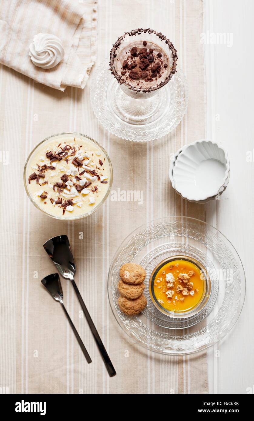 Pumpkin cream with amaretti biscuits, muscatel cream with meringue pieces, and coffee and ricotta cream with chocolate biscuit pieces Stock Photo
