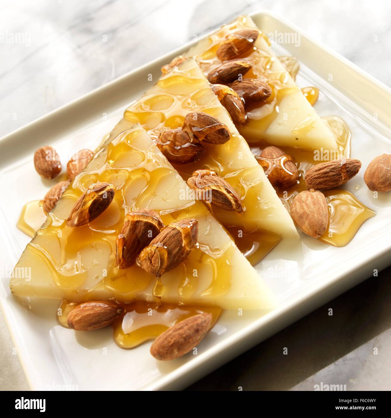 Thin Wedges of Manchego Cheese with Roasted Almonds and Honey Stock