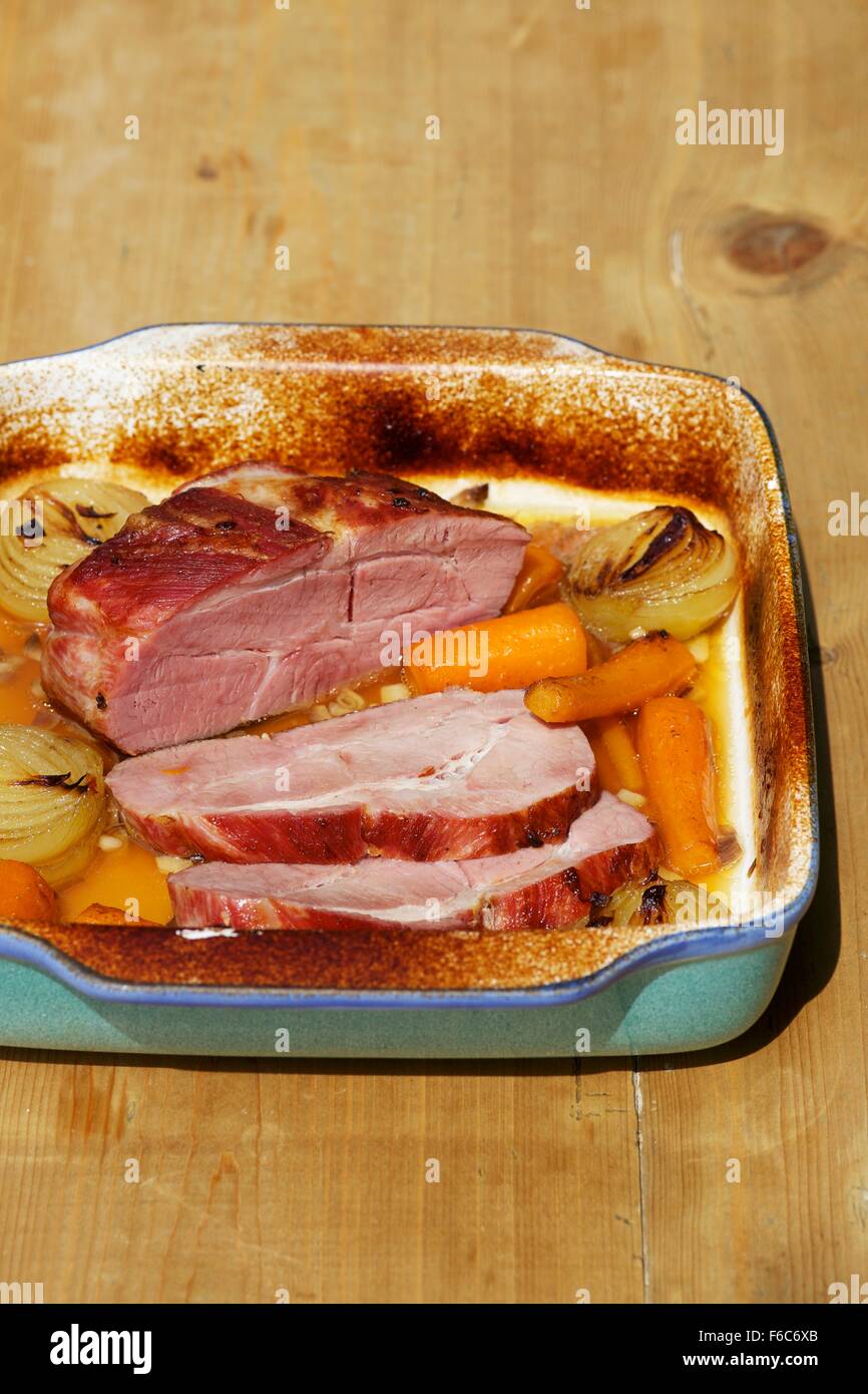 Roast ham with vegetables in the roasting tin Stock Photo Alamy