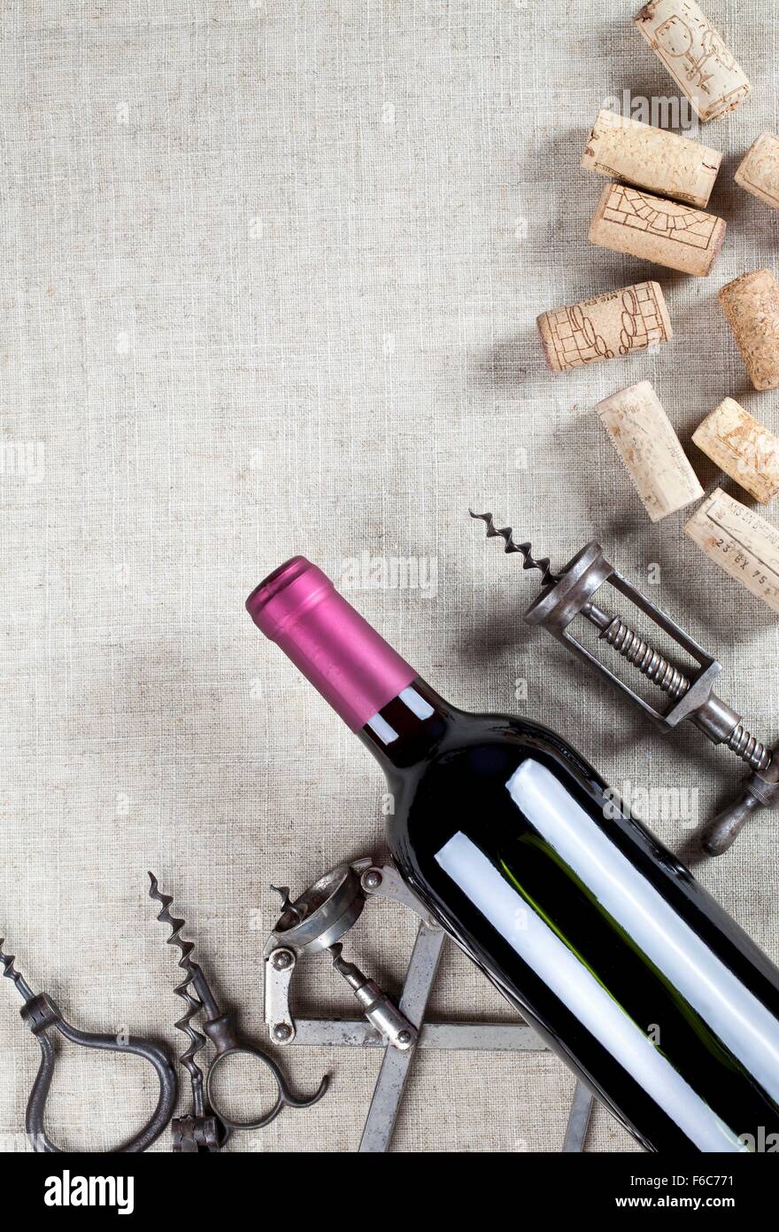 A bottle of red wine, old corkscrews and wine corks Stock Photo