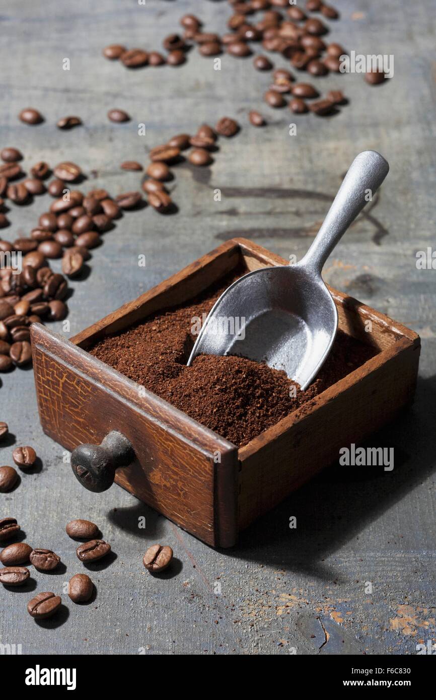 Ground coffee beans in a drawer belonging to an old coffee mill Stock Photo