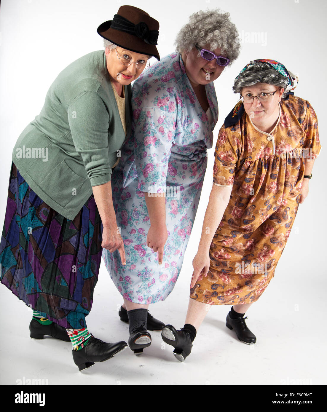 A group of comedy performers stand in the studio, posing for a