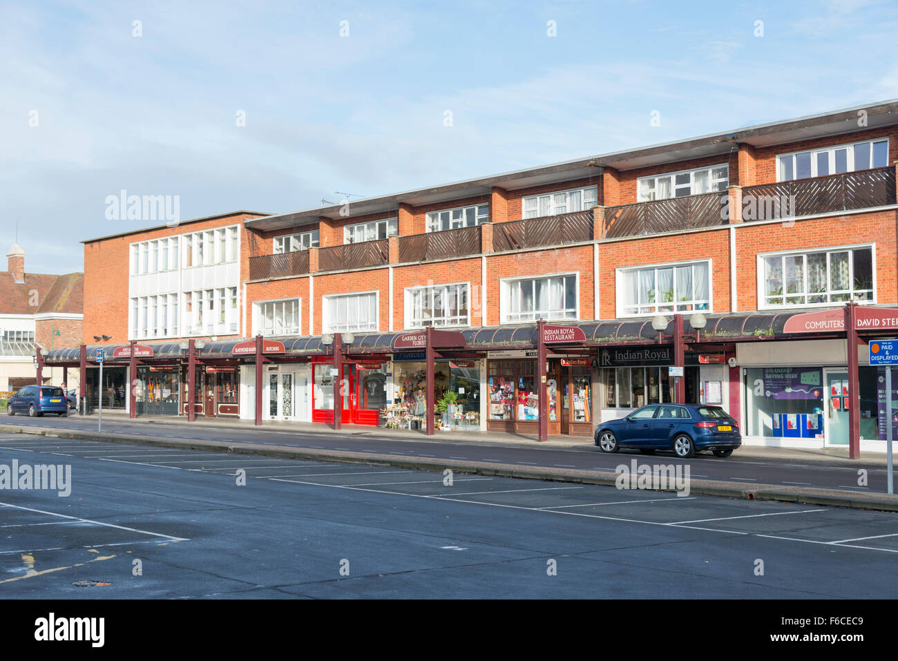 A row of shops and parking on a street in Letchworth Garden City showing ugly 1960's buildings and architecture Stock Photo