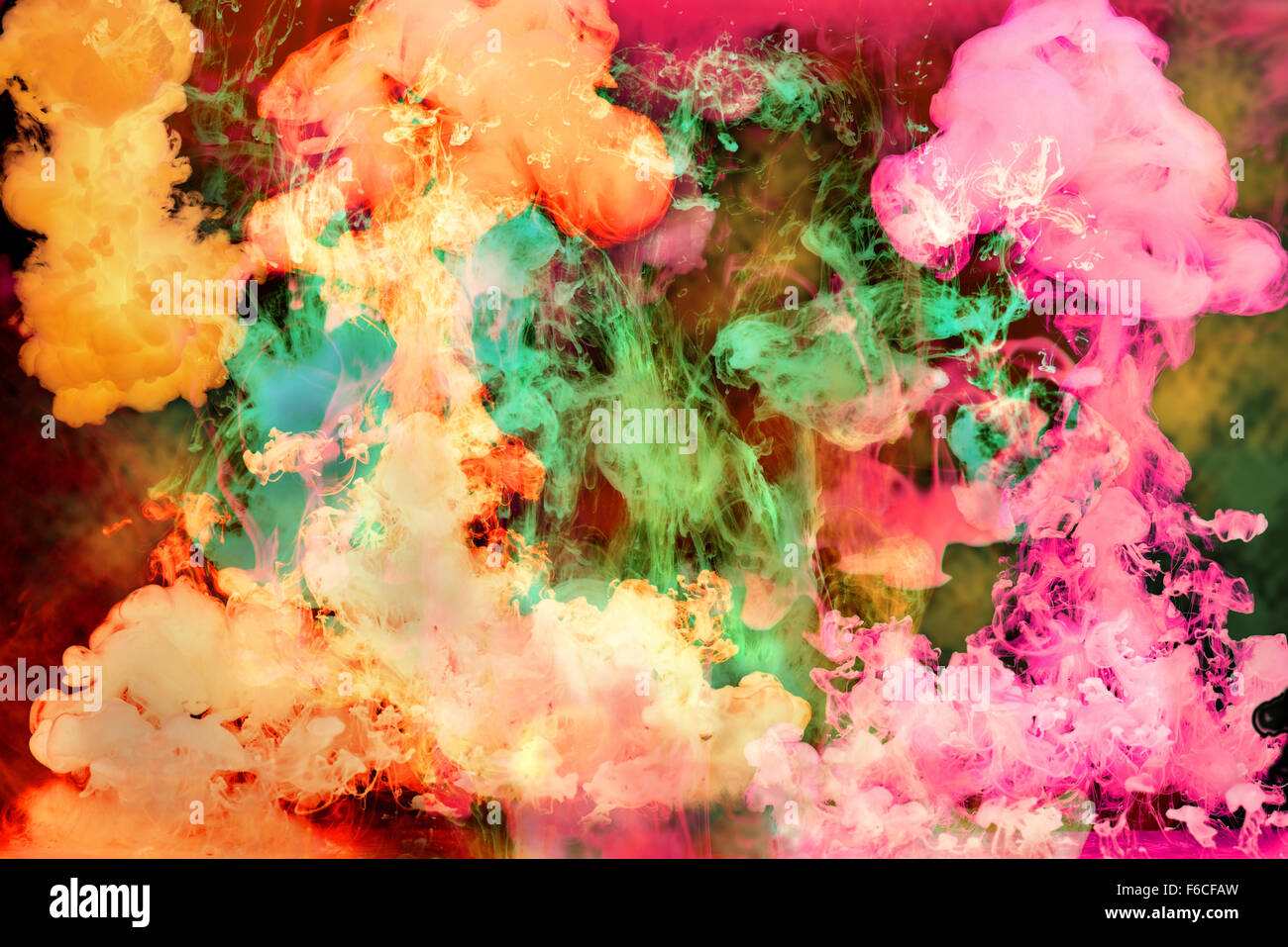 Colorful bright inks dissolving in water over a dark background Stock Photo