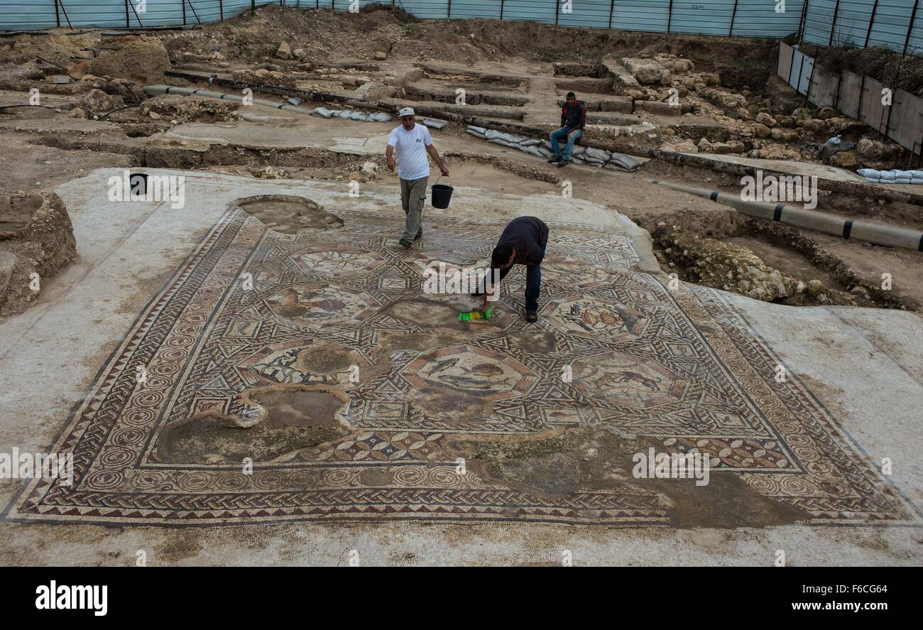 (151116) -- LOD (ISRAEL), Nov. 16, 2015 (Xinhua) -- Workers clean up a patch of the 1,700-year-old mosaic in Lod, a city east of Tel Aviv in central Israel, on Nov. 16, 2015. Israel's Antiquities Authority unveiled Monday a Roman-era floor mosaic, which was unearthed last year during constructions of a visitor center meant to exhibit another mosaic discovered two decades ago in the same place. Archaeologists said that the 'breathtaking' mosaic served as a floor of a villa's living room some 1,700 years ago. (Xinhua/Li Rui) Stock Photo