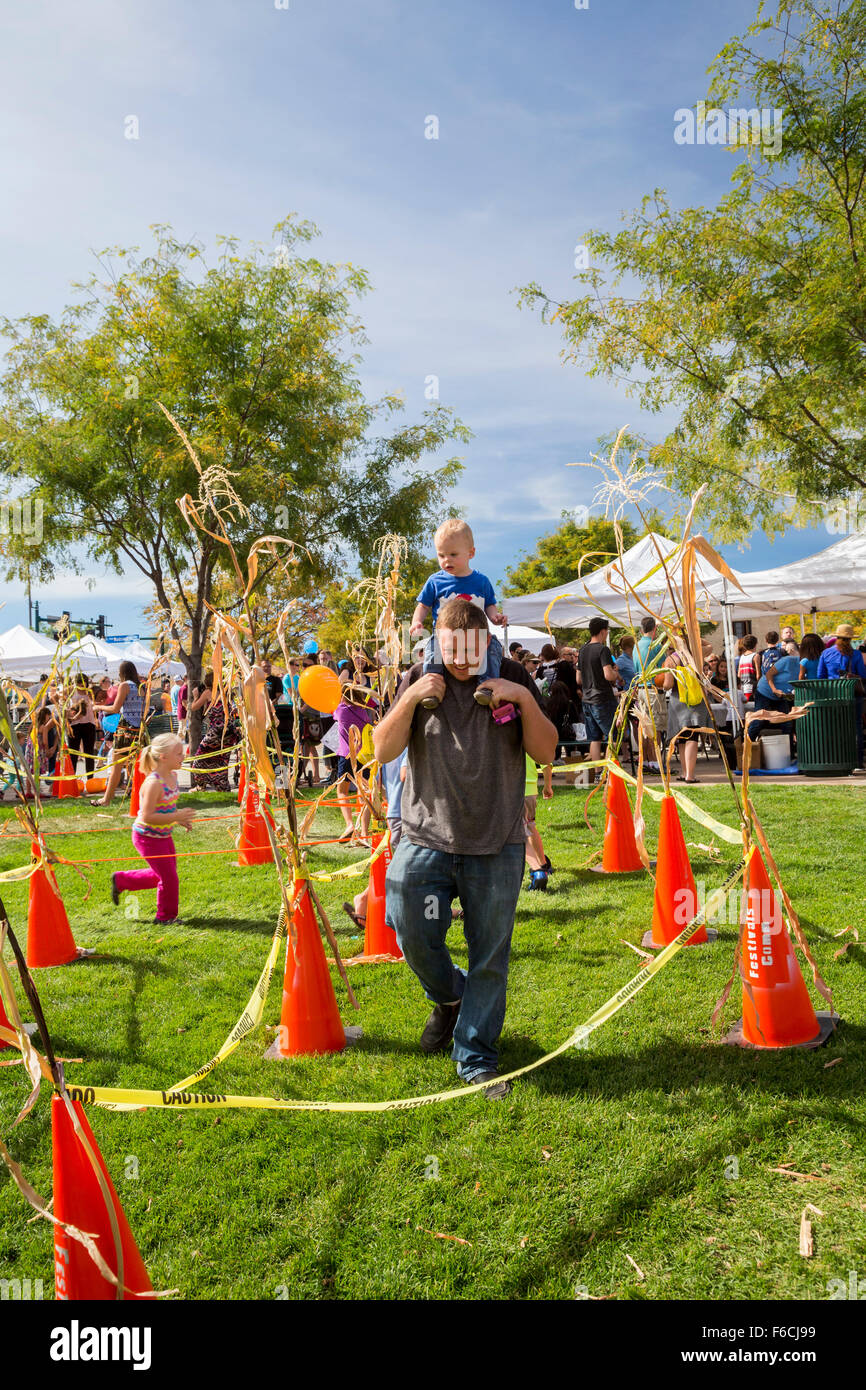 Arvada, Colorado - A dad carries his 15-month-old son through the 'cone maze' at the Festival of Scarecrows. Stock Photo