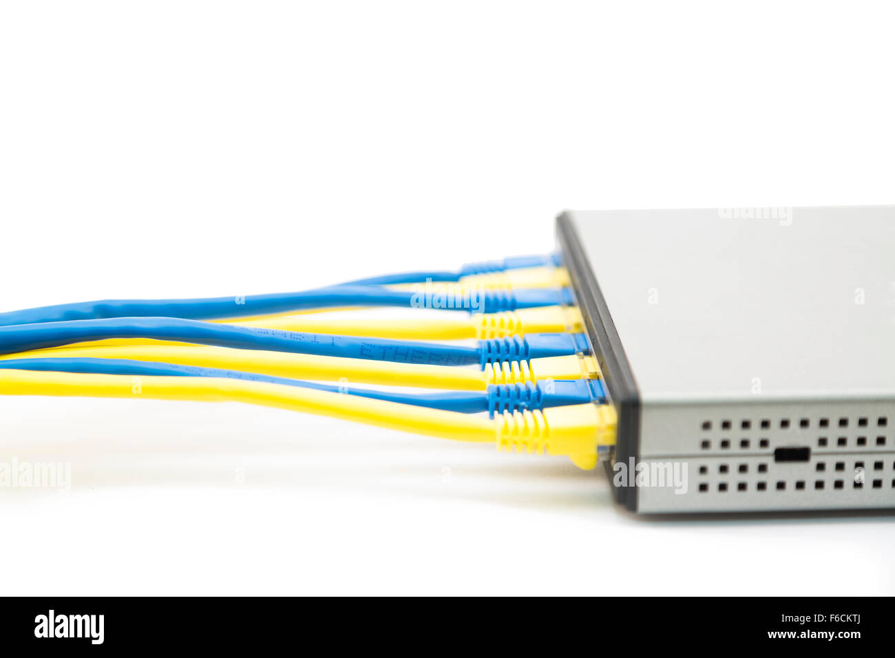 Network switch (router) with blue and yellow cables plugged in Stock