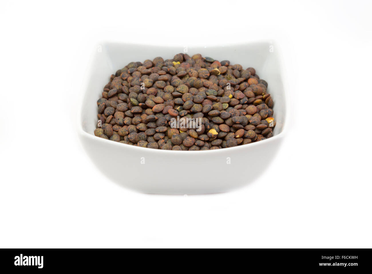 Green  Le Puy-en-Velay puy French lentils in a bowl against a white background Stock Photo