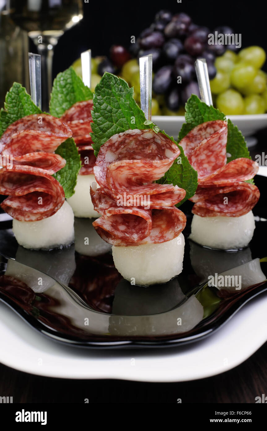 Canape of balls a melon and salami with mint Stock Photo