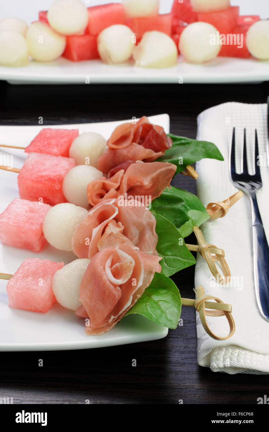 Appetizer of ham with melon and watermelon and basil on a skewer Stock Photo