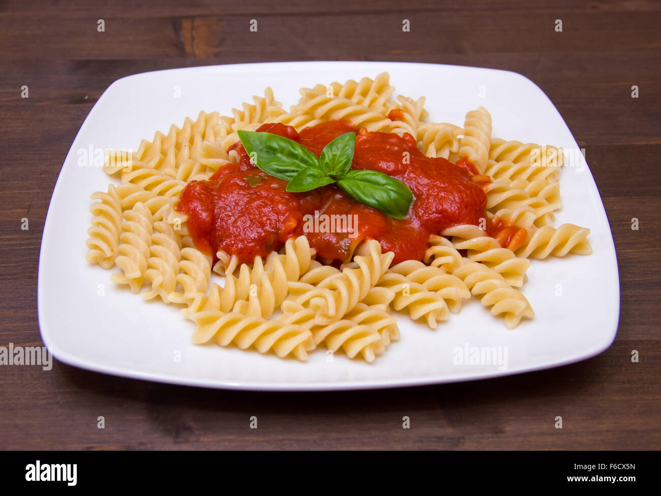 Fusilli with tomato sauce on wooden table Stock Photo - Alamy