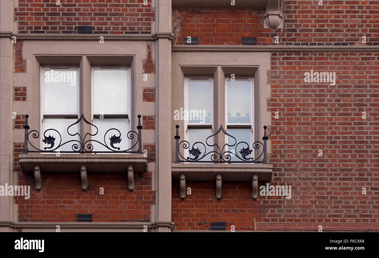 Ornate Iron Railing with Window. High up on a building is an ornate ...
