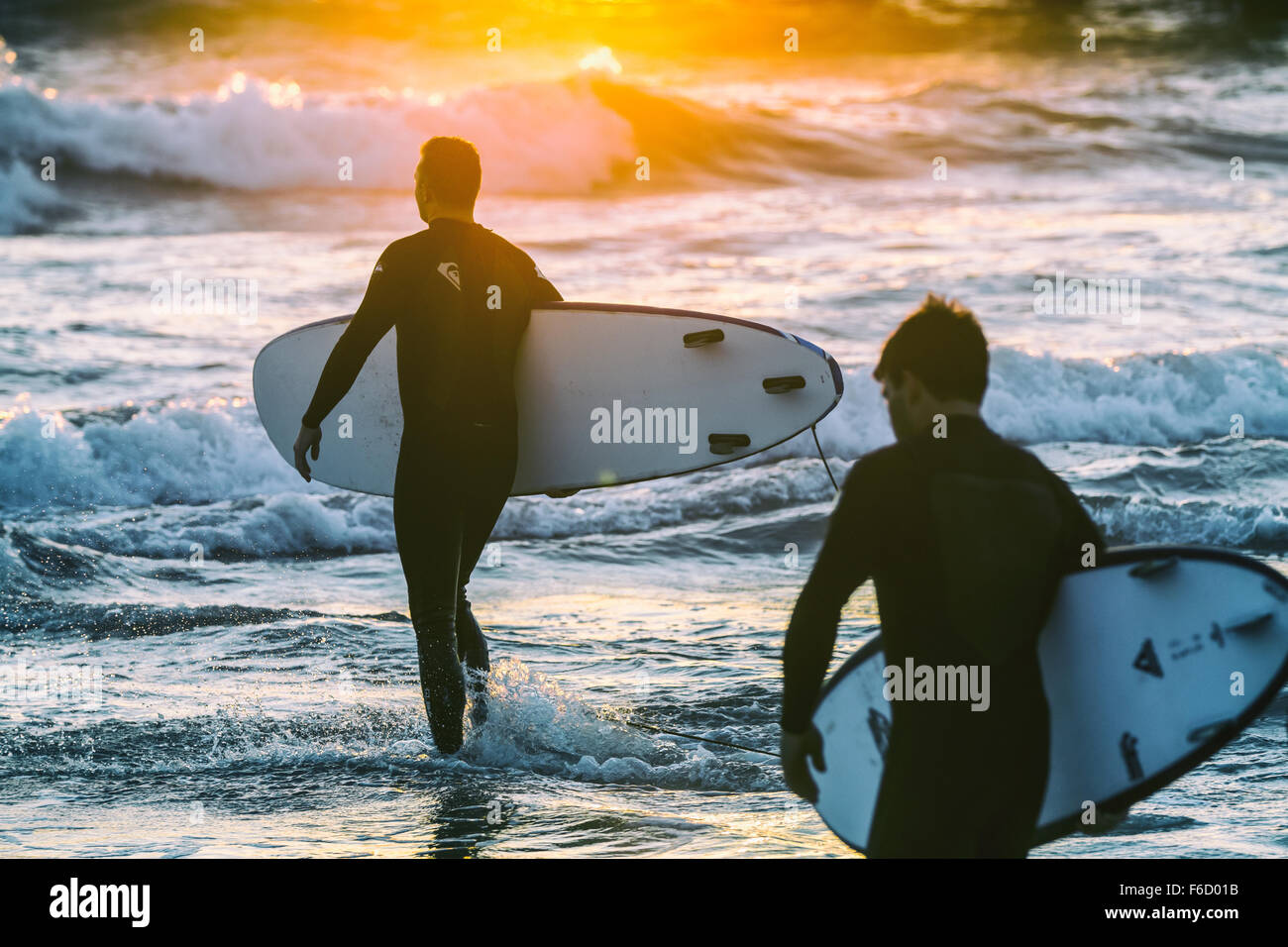 Two surfers going into the water. Stock Photo