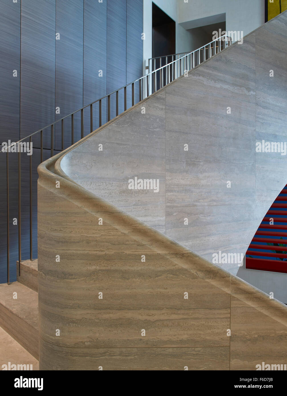 Curvature of stairway with handrail. Travertine Stair, London, United