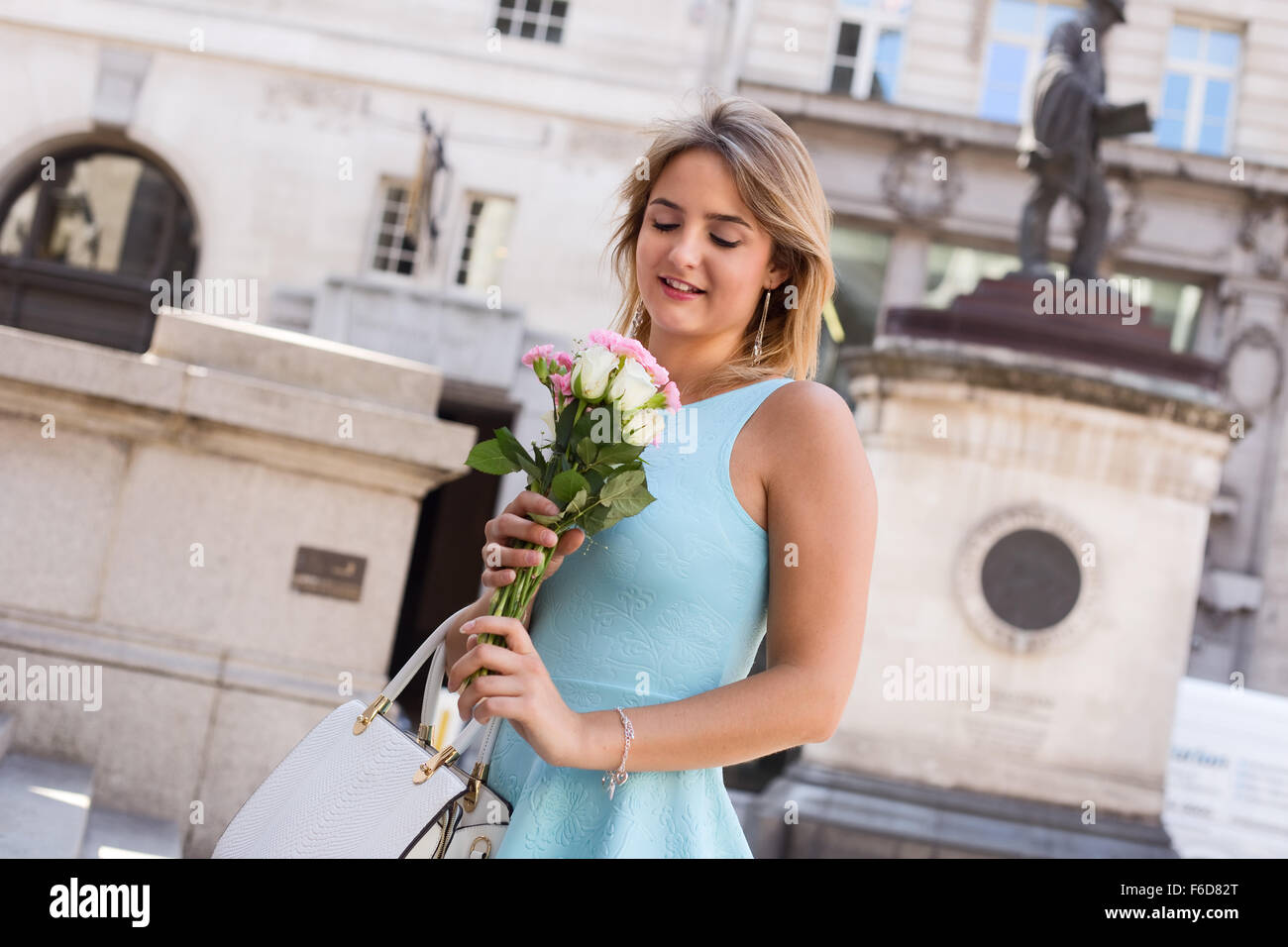 young woman in the city holding a bouquet of roses Stock Photo - Alamy