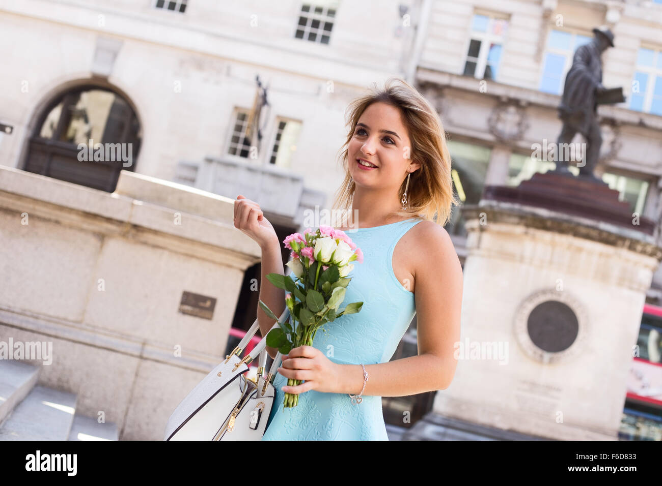 young woman in the street holding a bouquet of roses Stock Photo - Alamy