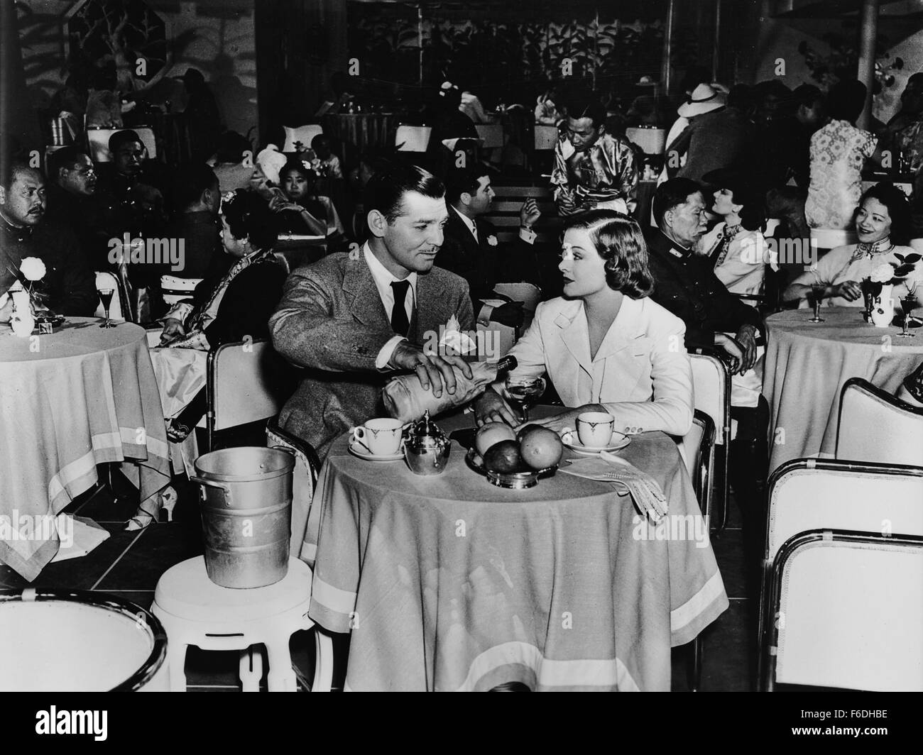 RELEASE DATE: September 16, 1938. MOVIE TITLE: Too Hot to Handle. STUDIO: Metro-Goldwyn-Mayer (MGM). PLOT: Chris Hunter is a sly newsreel reporter. While in Shanghai doing reports on the Chinese-Japanese war, he meets pilot Alma Harding. At first she doesn't trust him, but by a trick he manages to get her hired as his assistant. During an adventurous expedition through the jungles of South America he manages to change her view of him. PICTURED: CLARK GABLE as Christopher Hunter and MYRNA LOY as Alma Harding. Stock Photo