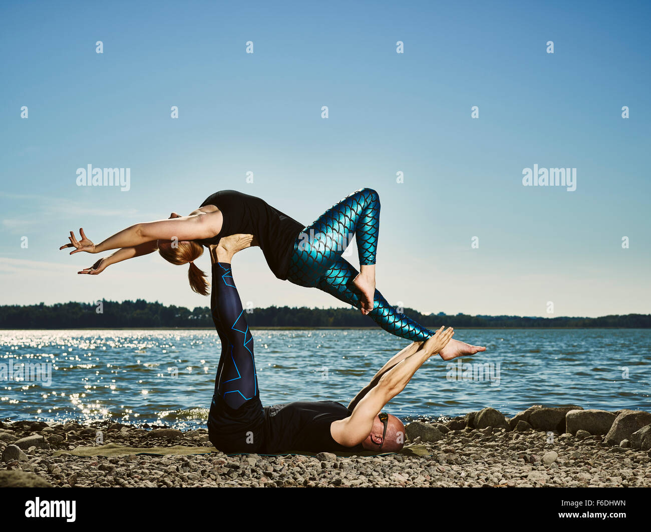 Sporty couple training acro yoga outdoors, summertime, sea and blue sky  Stock Photo - Alamy