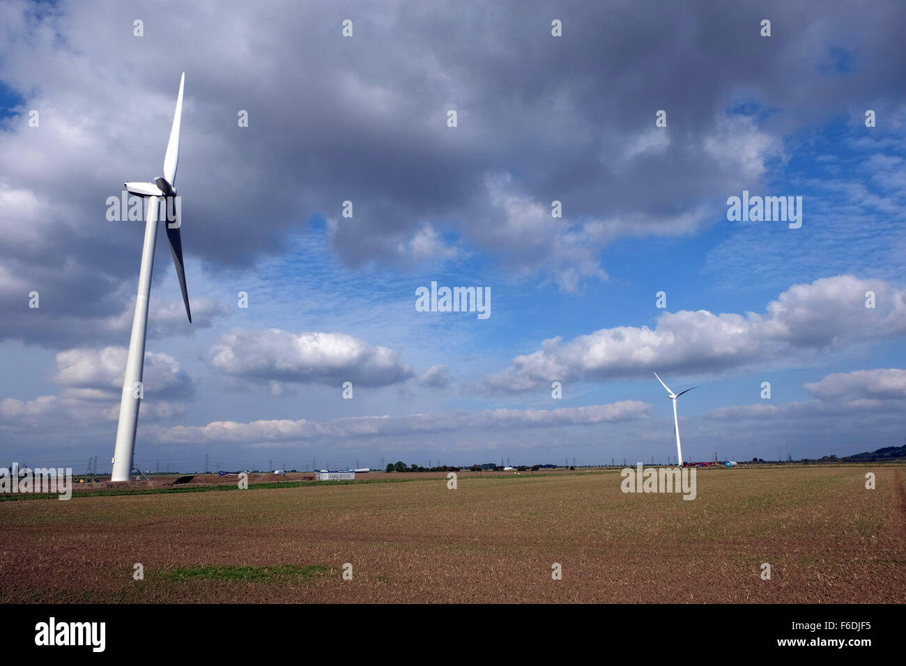 New wind turbines in flat open farmland. Stock Photo