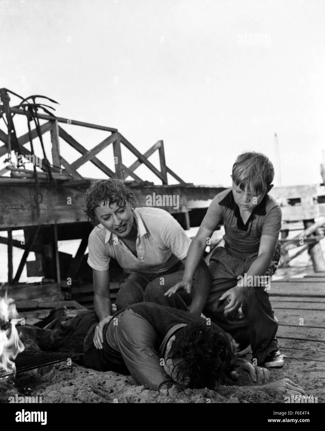 RELEASE DATE: March 30, 1953. MOVIE TITLE: Jeopardy. STUDIO: Metro-Goldwyn-Mayer (MGM). PLOT: The Stilwins are on vacation to an isolated beach in Mexico. Walking on a deserted jetty, Doug Stilwin gets his leg trapped under one of the logs. All attempts to move the log are futile and Helen Stilwin takes the car to get help. However, an escaped criminal kidnaps her. Will she be able to return to her husband before he drowns? PICTURED: BARBARA STANWYCK as Helen Stilwin, BARRY SULLIVAN as Doug Stilwin and LEE AAKER as Bobby Stilwin. Stock Photo