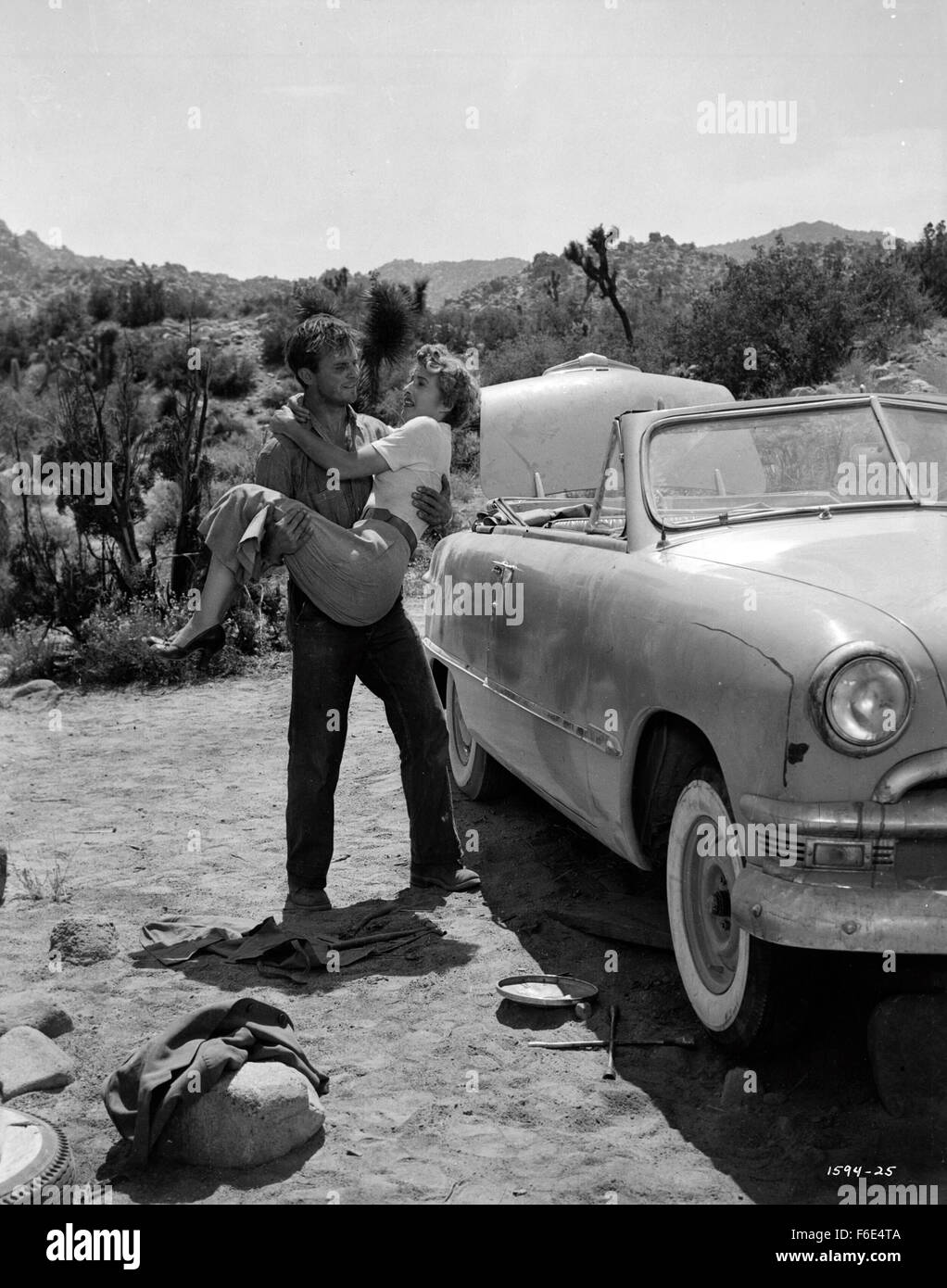 RELEASE DATE: March 30, 1953. MOVIE TITLE: Jeopardy. STUDIO: Metro-Goldwyn-Mayer (MGM). PLOT: The Stilwins are on vacation to an isolated beach in Mexico. Walking on a deserted jetty, Doug Stilwin gets his leg trapped under one of the logs. All attempts to move the log are futile and Helen Stilwin takes the car to get help. However, an escaped criminal kidnaps her. Will she be able to return to her husband before he drowns? PICTURED: BARBARA STANWYCK as Helen Stilwin and RALPH MEEKER as Lawson, the Fugitive. Stock Photo