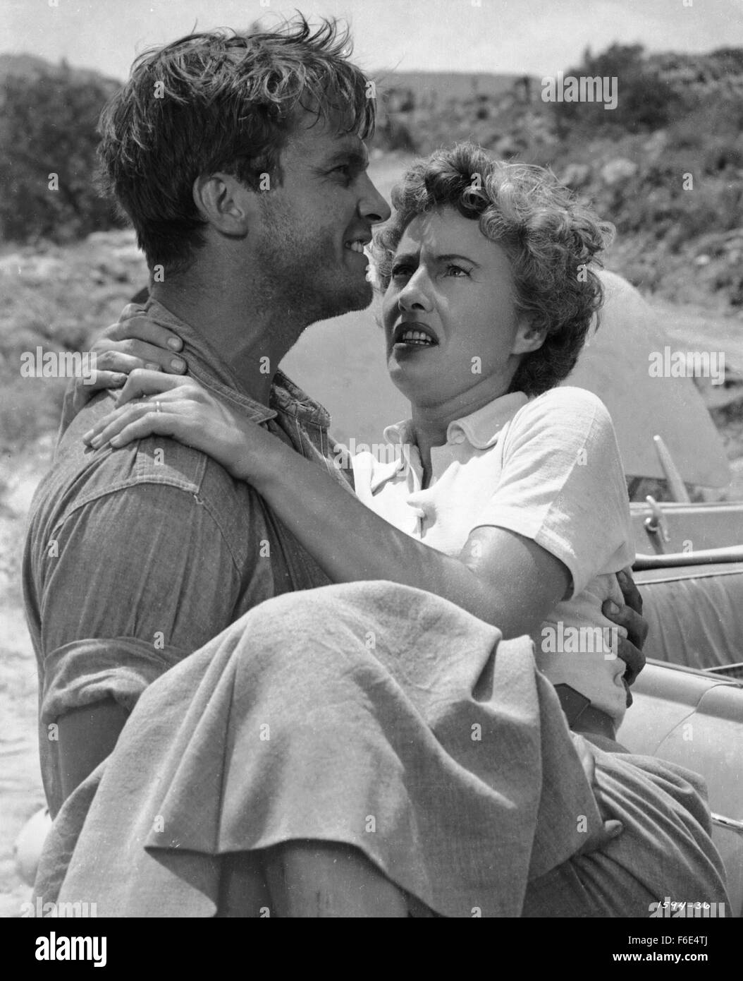 RELEASE DATE: March 30, 1953. MOVIE TITLE: Jeopardy. STUDIO: Metro-Goldwyn-Mayer (MGM). PLOT: The Stilwins are on vacation to an isolated beach in Mexico. Walking on a deserted jetty, Doug Stilwin gets his leg trapped under one of the logs. All attempts to move the log are futile and Helen Stilwin takes the car to get help. However, an escaped criminal kidnaps her. Will she be able to return to her husband before he drowns? PICTURED: BARBARA STANWYCK as Helen Stilwin and RALPH MEEKER as Lawson, the Fugitive. Stock Photo