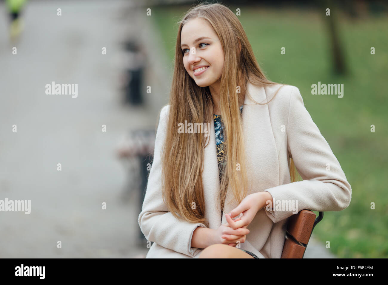 Young woman sitting on a bench in autumn park Stock Photo - Alamy