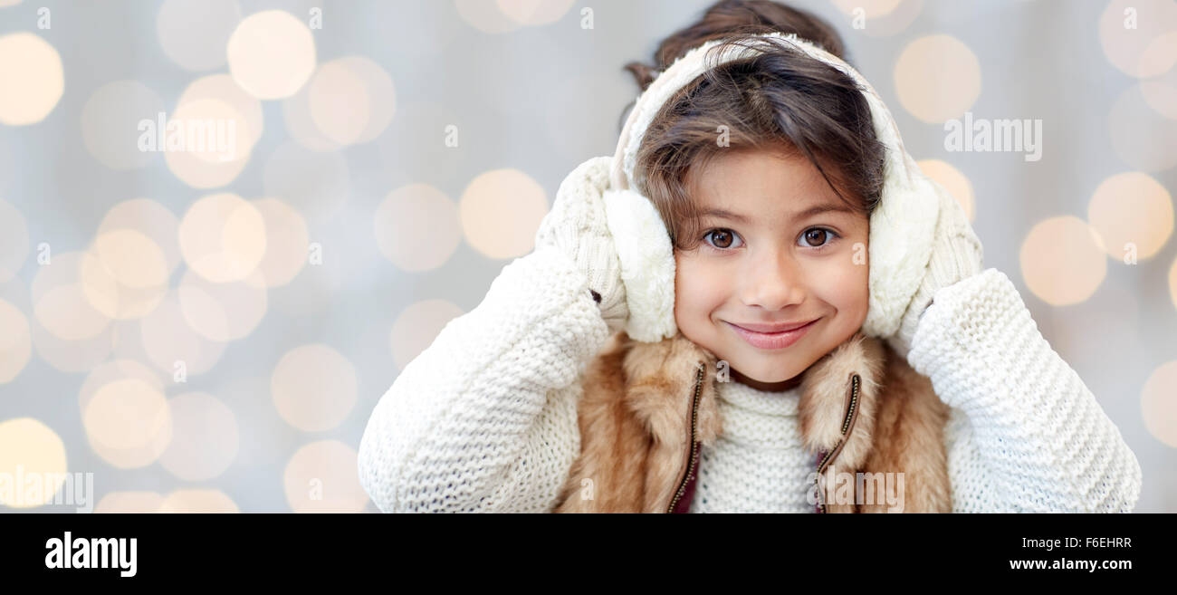happy little girl in earmuffs over holidays lights Stock Photo Alamy