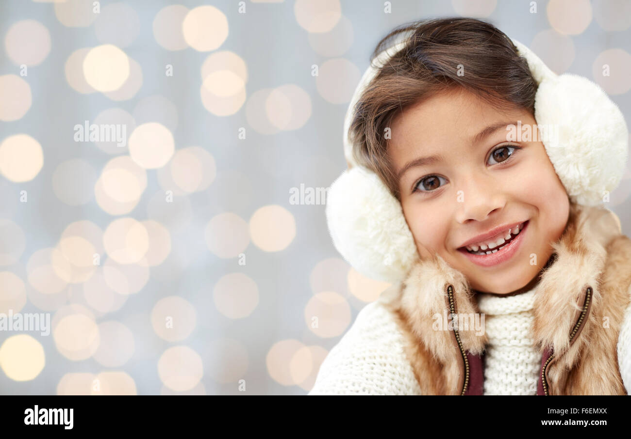 happy little girl in earmuffs over holidays lights Stock Photo Alamy