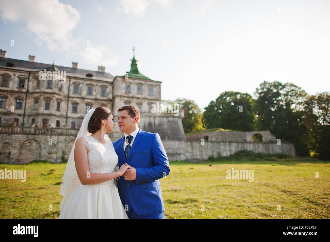 Young wedding couple on background old castle Stock Photo - Alamy
