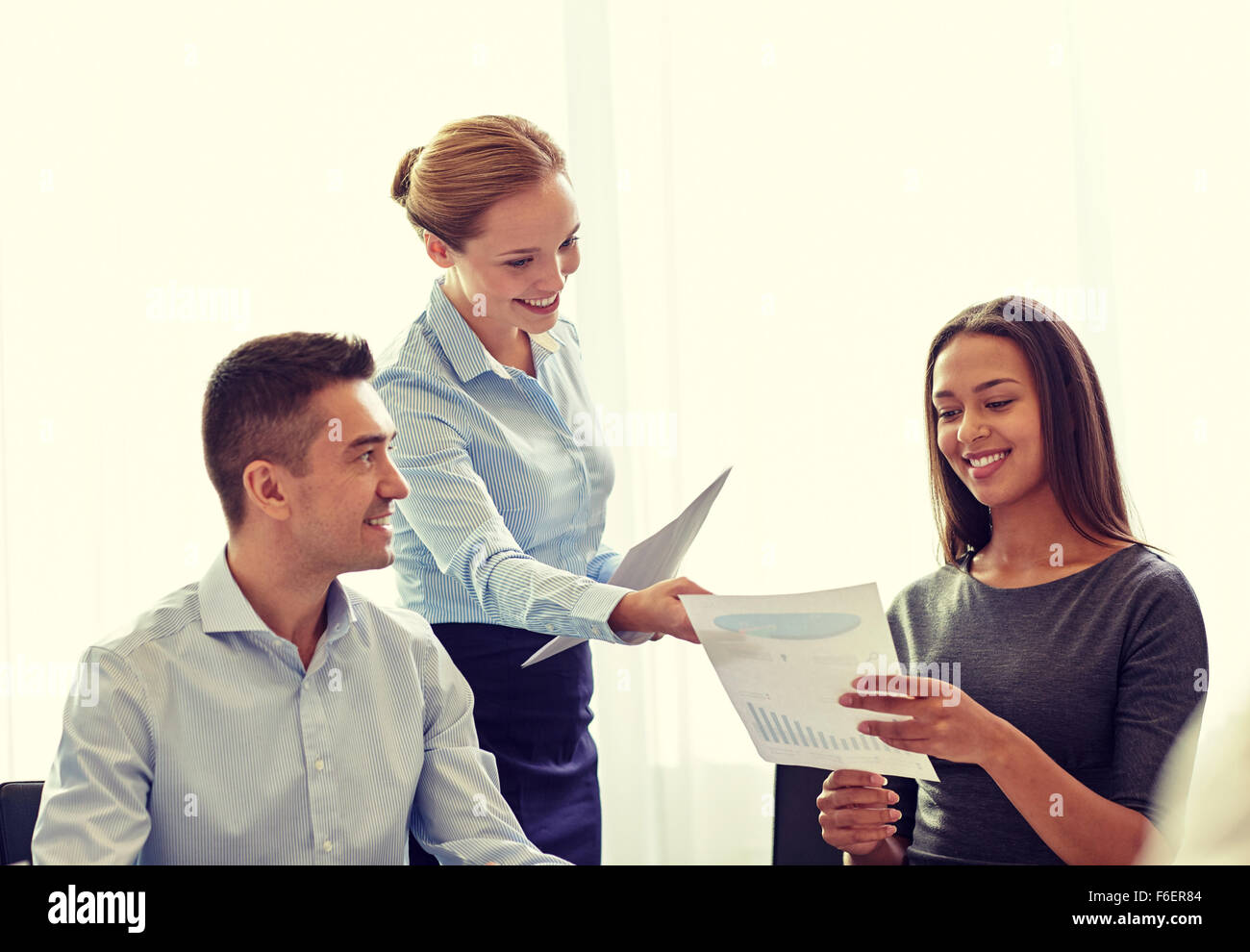 smiling business people with papers in office Stock Photo - Alamy
