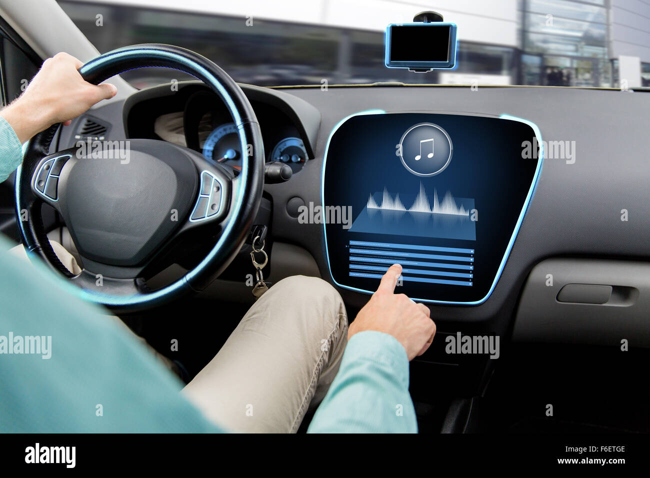 close up of man driving car with audio system Stock Photo