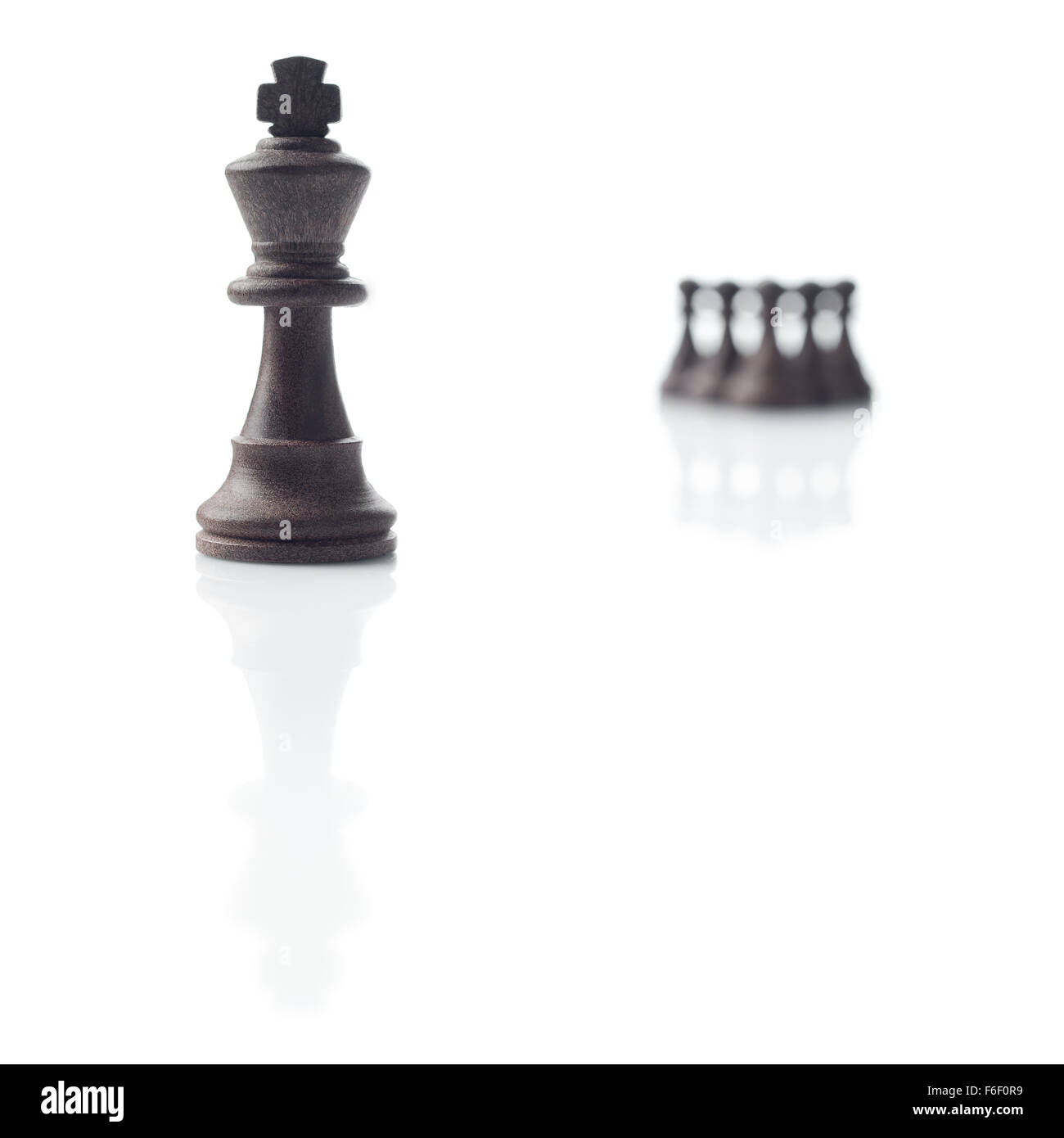 Chess. Black king, five pawns out of focus and their shadows on white background Stock Photo