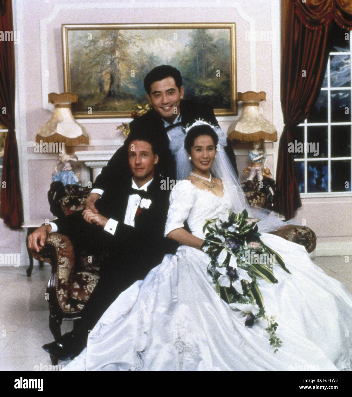 RELEASE DATE: Aug 04, 1993. MOVIE TITLE: The Wedding Banquet aka Hsi yen. STUDIO: The Samuel Goldwyn Company. PLOT: A gay Taiwanese-American man is in a happy long term relationship in Manhattan, but his parents in Taiwan are always pressuring him to marry. His tenant, a young Chinese girl needs to marry an American citizen to obtain her green card, so a deal is made. Complications arise when the joyous parents arrive for the wedding and a huge cross-cultural banquet is arranged to celebrate. PICTURED: MITCHELL LICHTENSTEIN as Simon, WINSTON CHAO as Wai-Tung Gao, MAY CHIN as Wei-Wei. Stock Photo