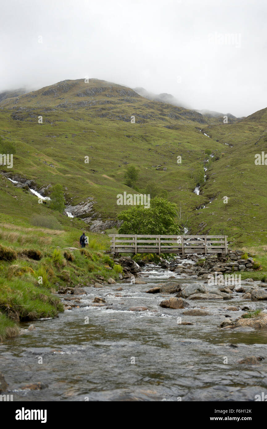 Wooden footbridge over Allt Coire Giubhsachan as it tumbles towards the Water of Nevis.  Built by R E Troop Oxford U O T C Stock Photo