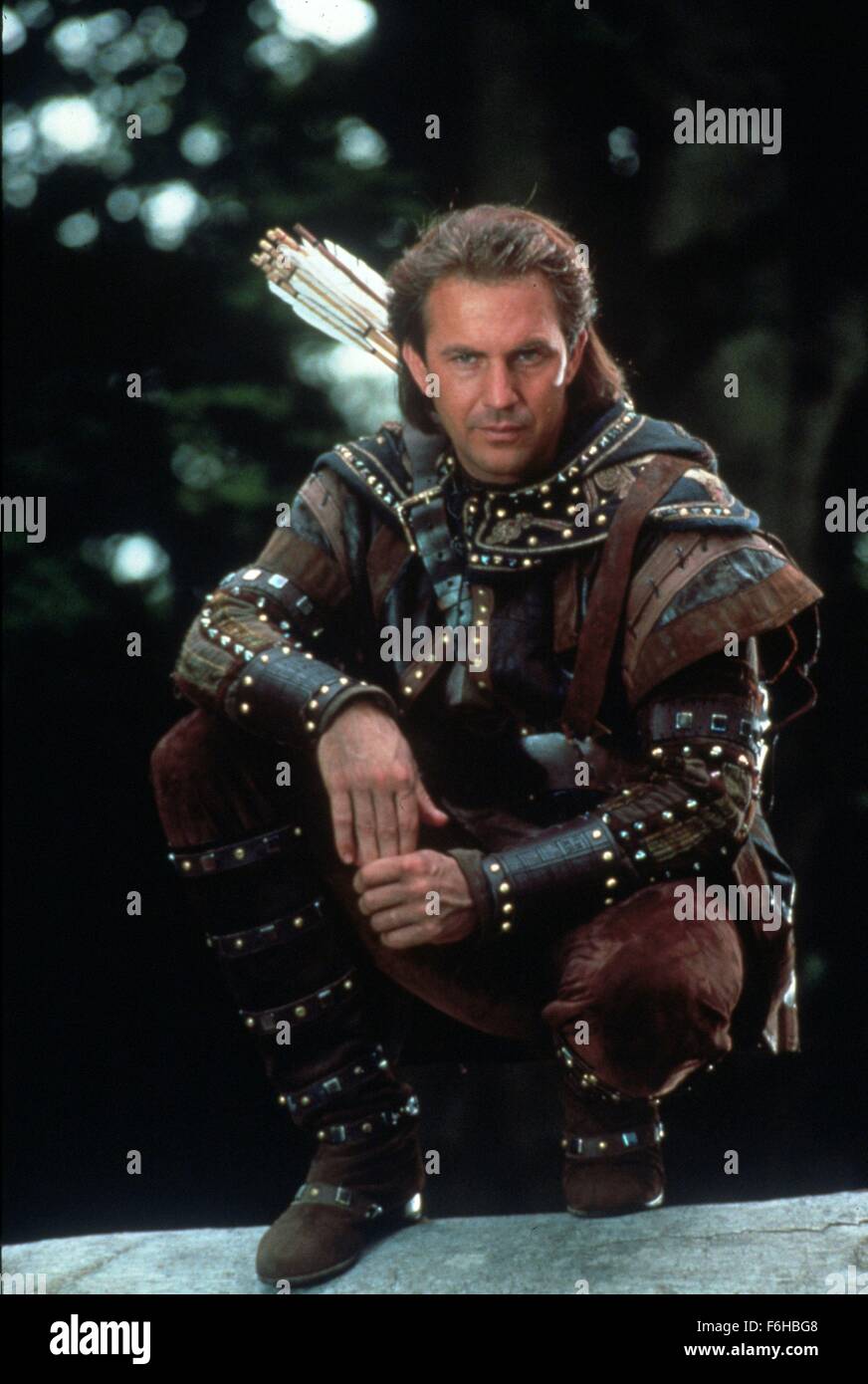 1991, Film Title: ROBIN HOOD: PRINCE OF THIEVES, Director: KEVIN REYNOLDS, Studio: WARNER, Pictured: 1991, CHARACTER, KEVIN COSTNER, ROBIN HOOD, COSTUME, OUTFIT - LEATHER, ARROWS, CROUCHING, GOOD CHARACTER, FOREST. (Credit Image: SNAP) Stock Photo