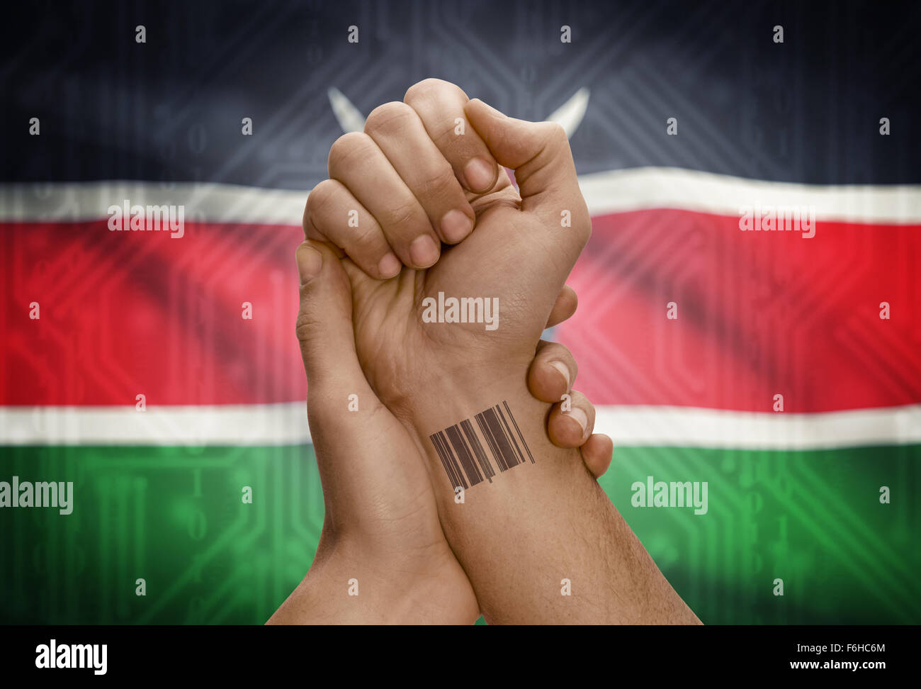 Barcode ID number tattoo on wrist of dark skinned person and national flag on background - Kenya Stock Photo