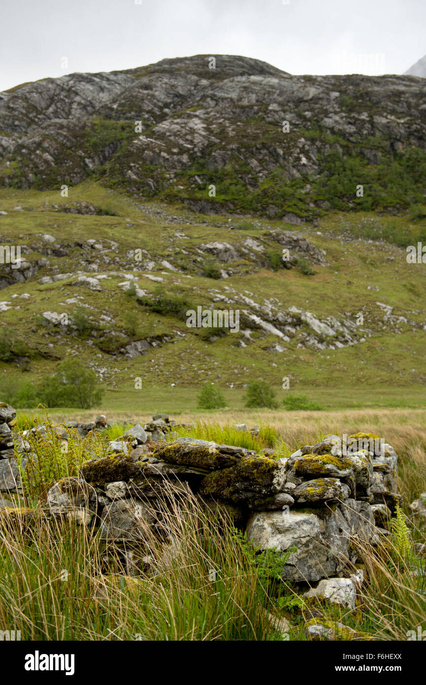 Part of the remains of an abandoned shiel provide the foreground for an image of the rocky Glen Nevis Stock Photo