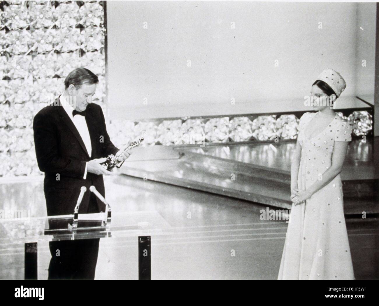 1969, Film Title: TRUE GRIT, Pictured: 1969, ACADEMY AWARDS CEREMONIES, ACCESSORIES, AWARDS - ACADEMY, BEST ACTOR, DOROTHY CHANDLER PAVILION, OSCAR (ACADEMY AWARD STATUE), BARBRA STREISAND, JOHN WAYNE, HOLDING AWARD, ACCEPTANCE SPEECH, TUXEDO, OSCAR RETRO. (Credit Image: SNAP) (Credit Image: c SNAP/Entertainment Pictures) Stock Photo