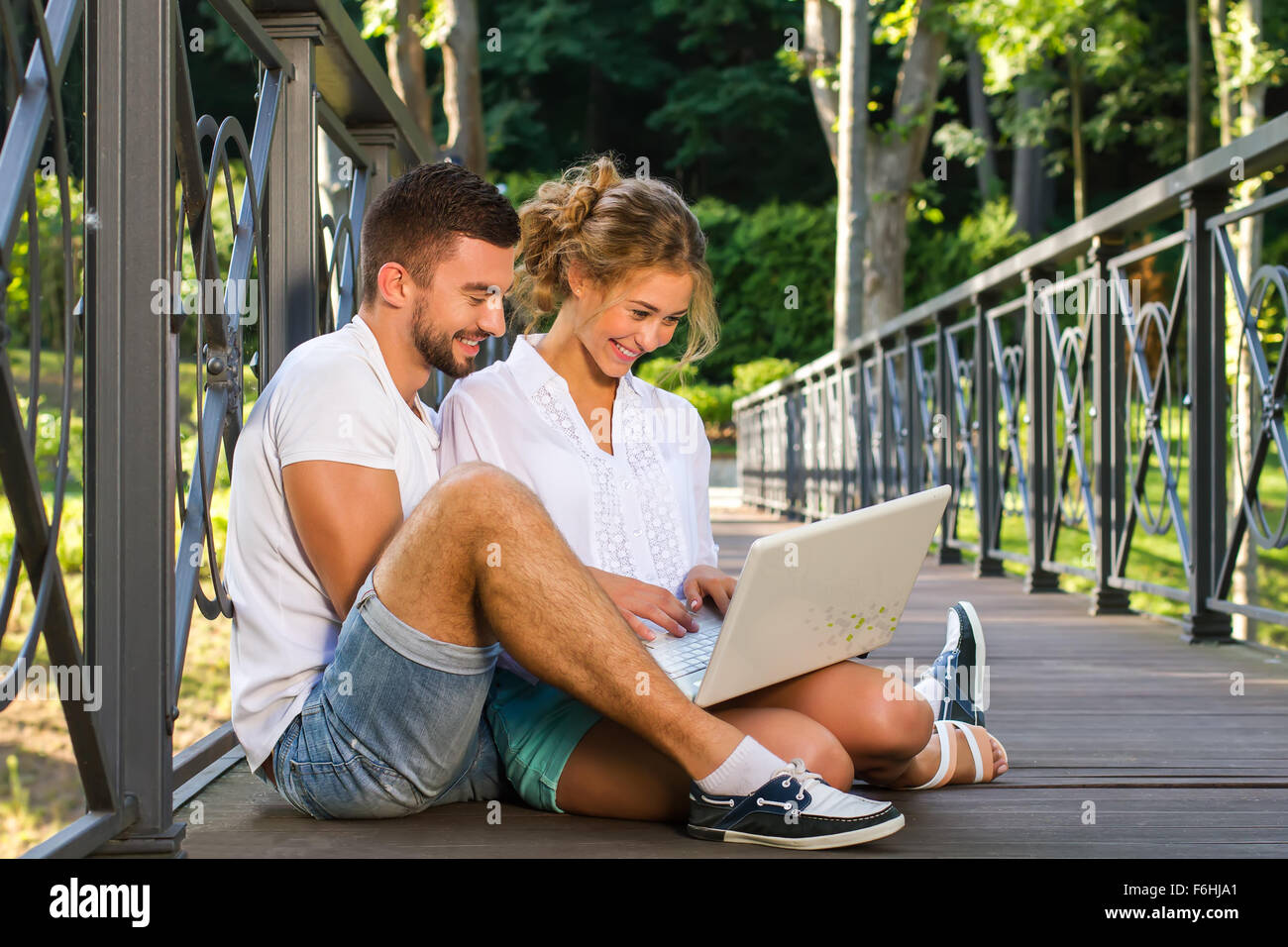 Couple sitting on the floor with laptop Stock Photo - Alamy