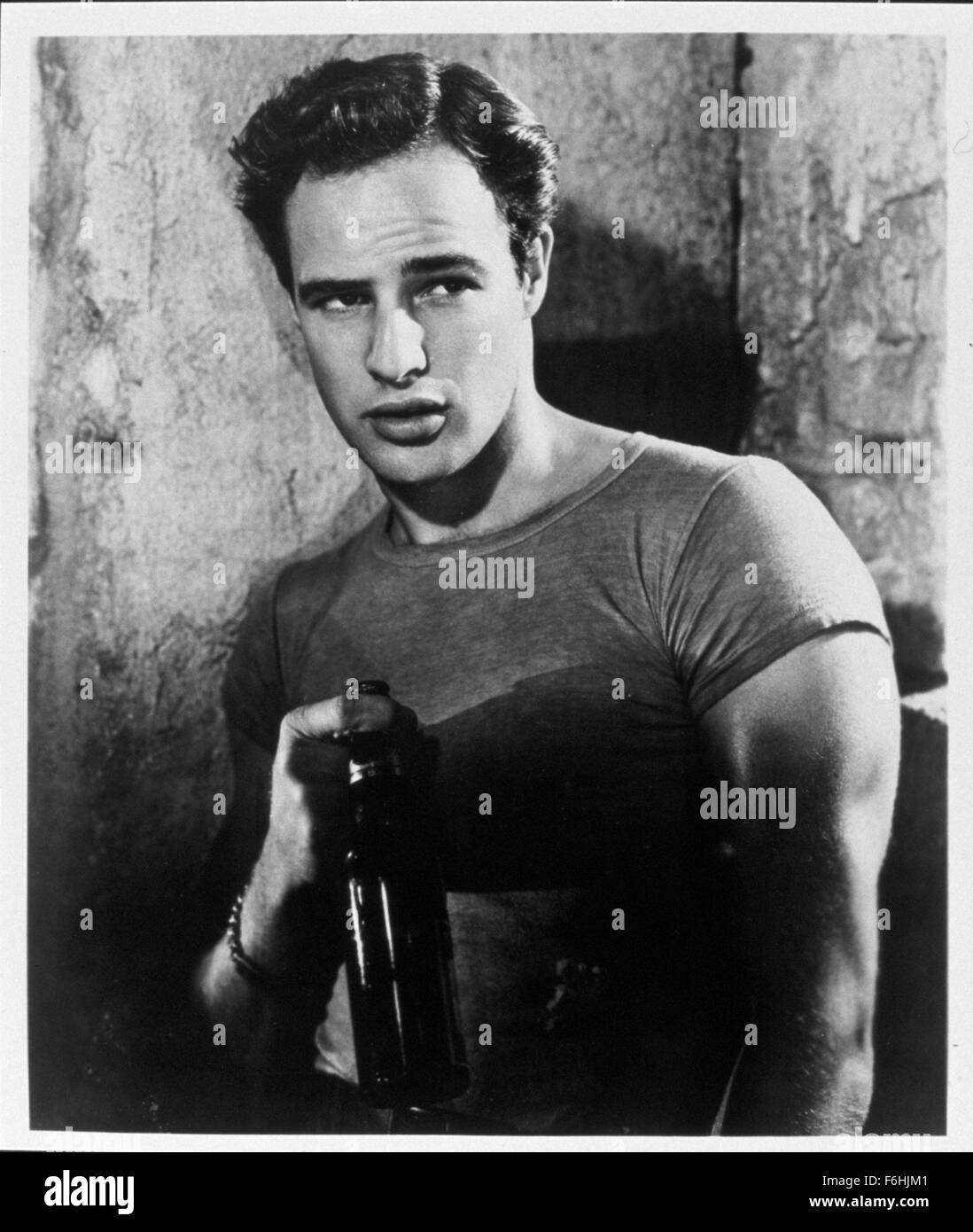 1951, Film Title: STREETCAR NAMED DESIRE, Director: ELIA KAZAN, Studio: WARNER, Pictured: 1951, MARLON BRANDO, CLOTHING, MEN - TOUGH, TEE SHIRT, T-SHIRT - GENERAL, MID SHOT, BEEFCAKE, BAD BOYS, TOUGH GUYS, DRINKING, MEN - POWERFUL, MEN - DOMINANT, MEN - AGGRESSIVE, BEER. (Credit Image: SNAP) Stock Photo