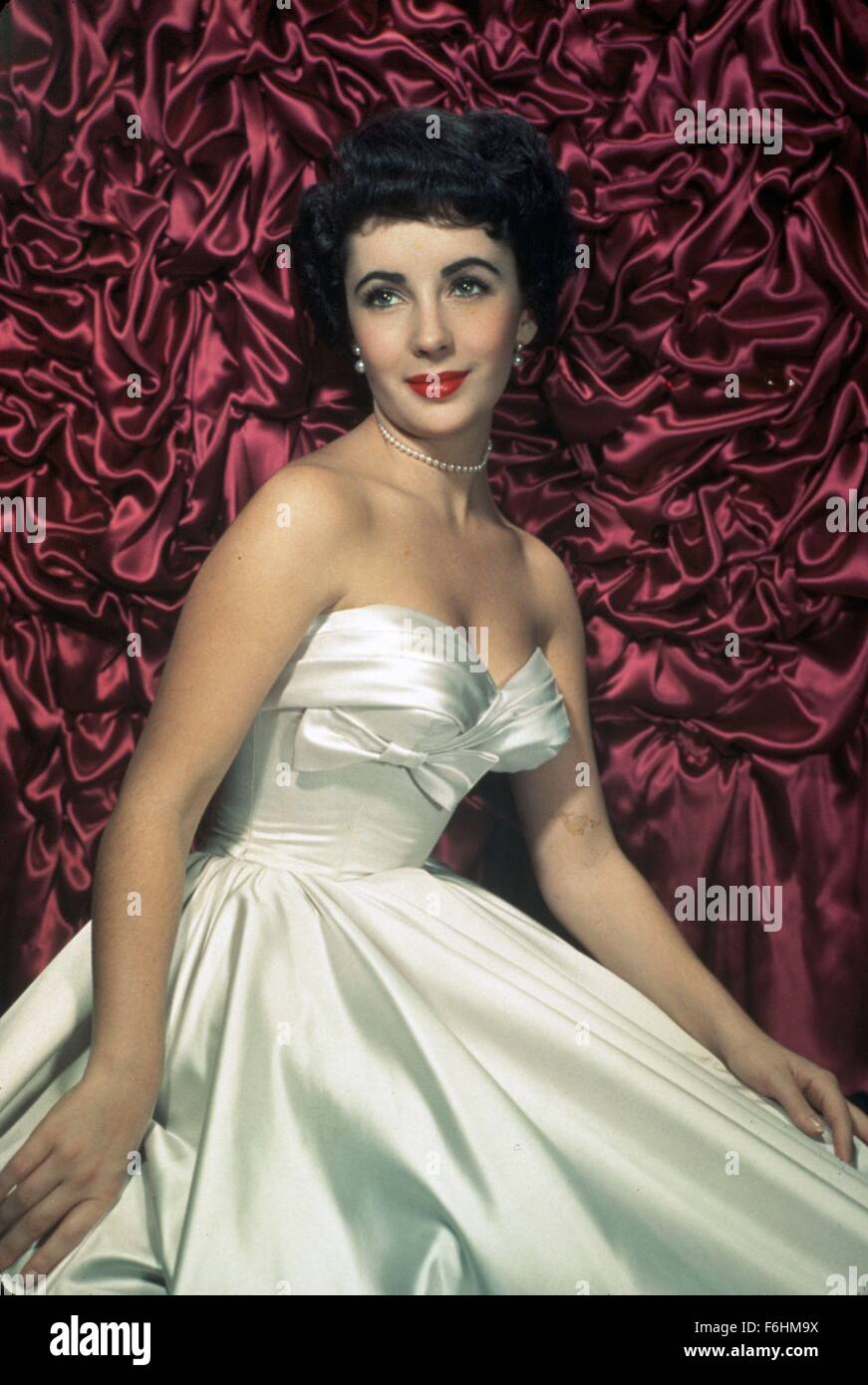 1951, Film Title: PLACE IN THE SUN, Director: GEORGE STEVENS, Pictured: PEARL KNECKLACE, ELIZABETH TAYLOR, PEARL EARINGS, RED LIPSTICK, SATIN DRESS, WHITE DRESS, LIZ TAYLOR, STUDIO, PORTRAIT, STRAPLESS DRESS, CLEAVAGE, EARRINGS - PEARL. (Credit Image: SNAP) Stock Photo