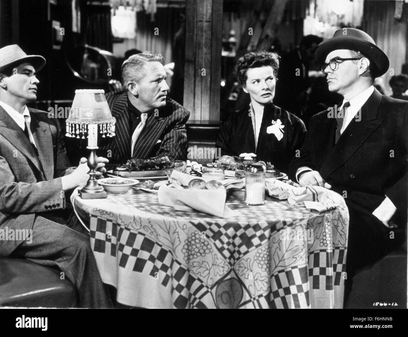 1952, Film Title: PAT AND MIKE, Director: GEORGE CUKOR, Studio: MGM, Pictured: CHARLES BRONSON, DINING ROOM TABLE, KATHARINE HEPBURN, GEORGE MATHEWS, SPENCER TRACY, CROOKS, GANGSTER, TABLE, SITTING, DINING, HAT, HAT - MENS, GLASSES. (Credit Image: SNAP) Stock Photo