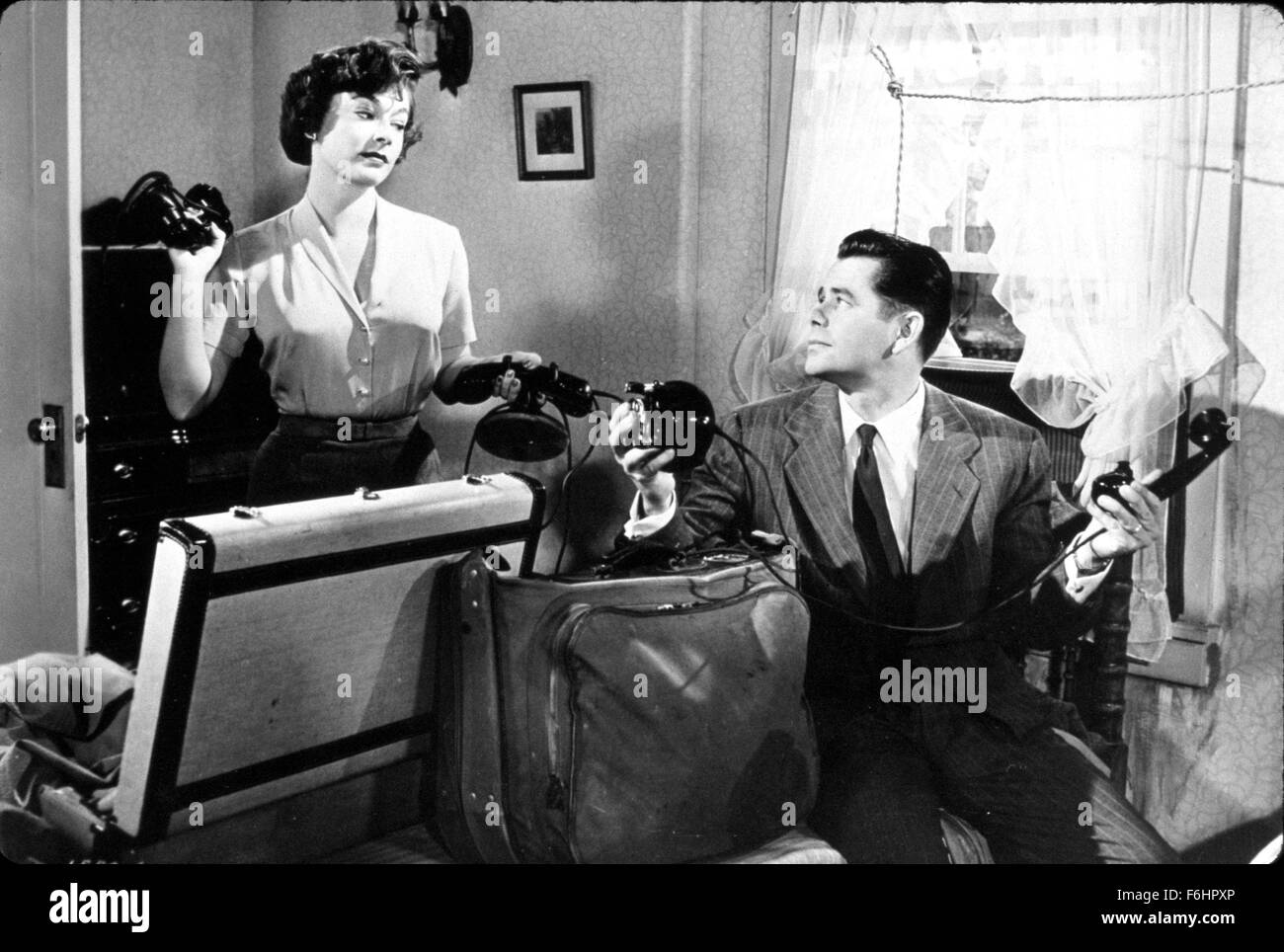 1952, Film Title: YOUNG MAN WITH IDEAS, Director: MITCHELL LEISEN, Studio: MGM, Pictured: GLENN FORD, RUTH ROMAN, TELEPHONING, DISAPPROVAL, CONFLICT, TUG O WAR, LUGGAGE, PACKING, SUIT CASE. (Credit Image: SNAP) Stock Photo